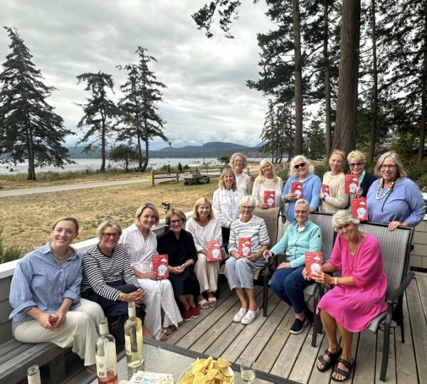 group of women gathered on a shoreline deck