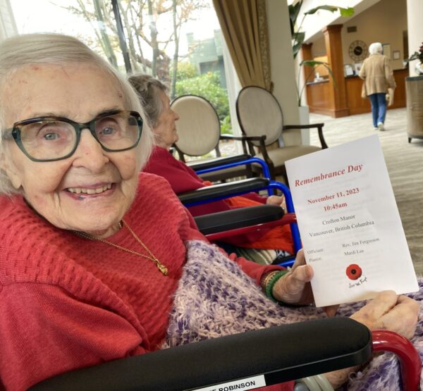 Elderly lady holding up Remembrance Day pamphlet