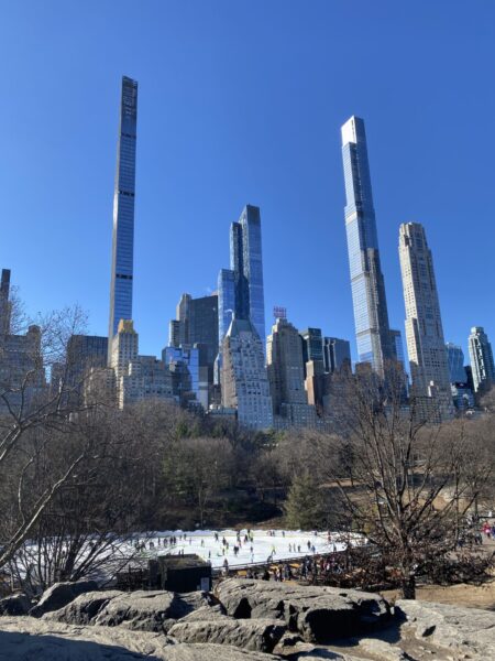 Skaters below skinny skyscrapers