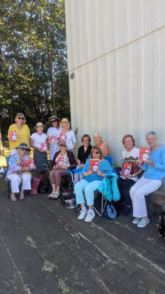 group of women holding up a book